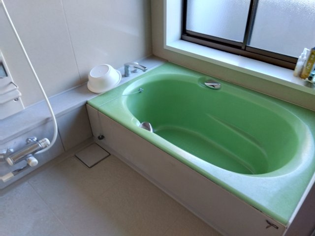 売住付店舗　三島市東大場2丁目の浴室|窓があるので明るい室内です。緑の可愛らしい浴槽です。備え付けの台があるのでシャンプーを置けて便利です。