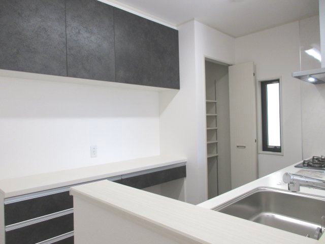 昭島市中神町２丁目　未入居住宅のキッチン|キッチンには備え付けのカップボードが標準でついています。キッチンと色合いも統一されて収納豊富な設備。