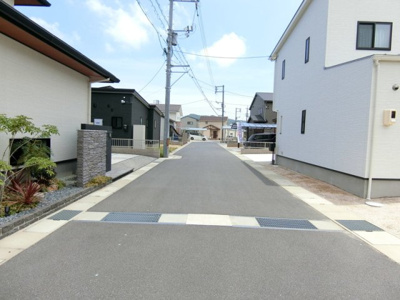 【前面道路含む現地写真】 | 新築　金光町須恵　4LDK | 前面道路は幅員6ｍでゆとりがあります。南道路なのでお家の中に日の光も差し込み明るくお過ごしいただけます。