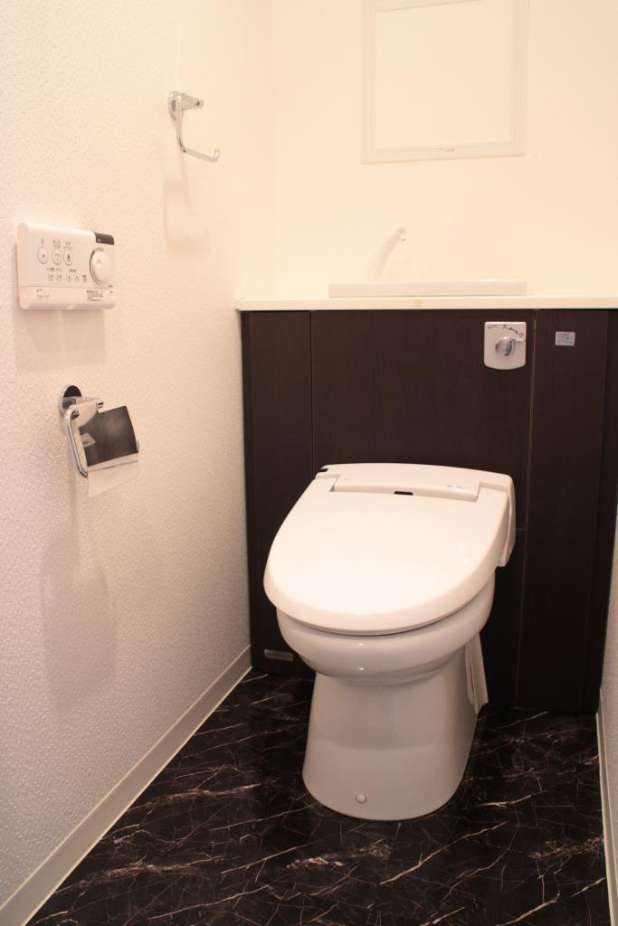 エグゼ神宮前のトイレ|温水洗浄機能付き便座。上部に収納棚あり。