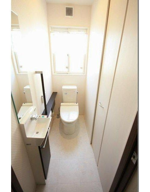 上林町　戸建のトイレ|1階トイレには天井高まである収納が備わっており使い勝手の良いトイレです。