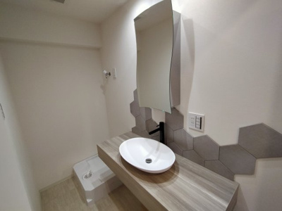 【洗面所】 | 鶴見緑地コーポ | デザイン性のあるおしゃれな洗面台です。奥には洗濯機から床への漏水を防ぐことが出来る防水パン設置済み。