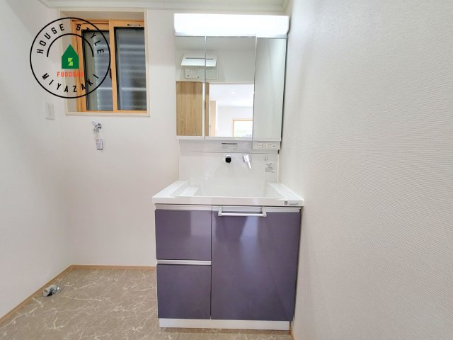 宮崎市第3恒久宮ノ後モデル（１号棟）の独立洗面台|毎日使うものだから清潔な空間を保ちたい水回り。洗面にはそんな願いを解消させてくれる収納アイデアが満載です。三面鏡の裏側にはキャビネットが現れ小物から背の高い物まで収納できます。