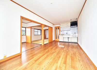 【居間・リビング】 | グリーンハイツ松本 | 9.5帖DK。隣の洋室の扉は大きく開くタイプです。