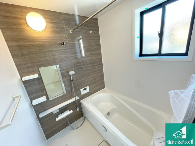 近江八幡市中村町　第1期　新築一戸建ての浴室|足をゆったり伸ばして寛げる浴槽です。窓が設けられていますので差し込む光が明るく穏やかな雰囲気にしてくれます♪浴室乾燥機も設置しているので、雨の日の洗濯物も安心です♪