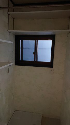 粟田口鳥居町戸建の洗面所|作り付けの棚が洗濯パンの上にあります。