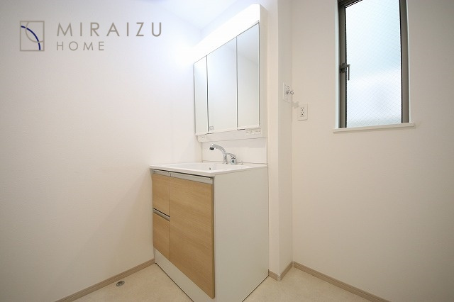 【洗面所】 | 洗濯機置き場と脱衣スペースもしっかりと確保されている洗面室、洗面コーナーは、窓から陽も差し明るく開放的な造りです。家事導線も良いので洗濯物やお湯はりもストレスフリーに毎日家事を楽しめそうです。
