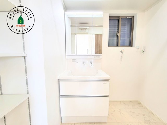 パティオニュータウン月見ヶ丘（41号棟）の独立洗面台|毎日使うものだから清潔な空間を保ちたい水回り。洗面にはそんな願いを解消させてくれる収納アイデアが満載です。三面鏡の裏側にはキャビネットが現れ小物から背の高い物まで収納できます。