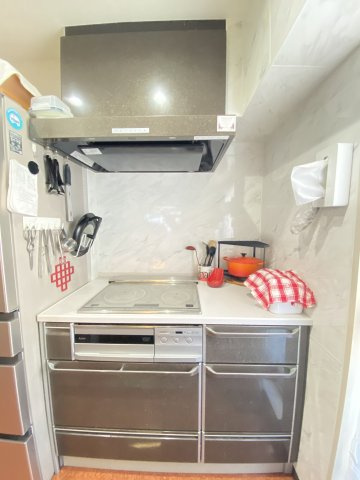 コンロはIHを採用。キッチン回りはホーローキッチンパネルが設置されており、油跳ねのお掃除も楽々。マグネットが付くのでマグネット収納を自在に配置できます。