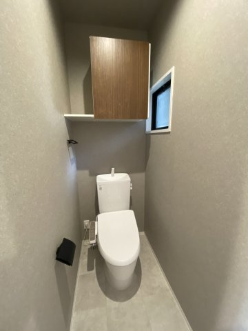 セジュール碧Cのトイレ|落ち着いたカラーの内装、収納棚、温水洗浄暖房便座付き。