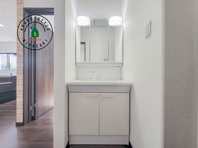 都城市乙房町（D号棟）の独立洗面台|毎日使うものだから清潔な空間を保ちたい水回り。洗面にはそんな願いを解消させてくれる収納アイデアが満載です。三面鏡の裏側にはキャビネットが現れ小物から背の高い物まで収納できます。