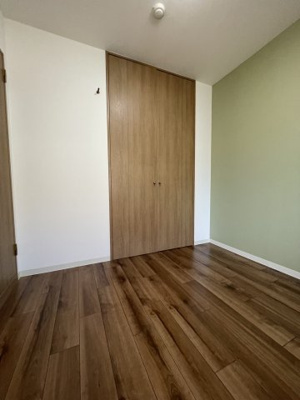 【洋室】 | ディオフェルティ石切 | 洋室（約4.5帖）：グリーンのアクセントクロスとフローリングのブラウンが柔らかな印象のお部屋です。