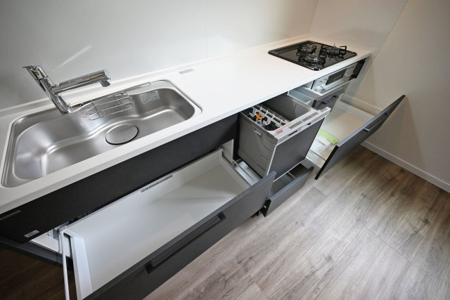 尼崎市東園田7丁目新築一戸建て│前面道路6ｍ+完成済のキッチン|天板とワークトップ下いっぱいの収納。食洗器もビルトインしており、効率の良い家事が実現する設備で小さなお子様のいるご家庭の大きな手助けをいたします。