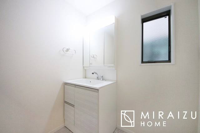 【洗面所】 | 洗濯機置き場と脱衣スペースもしっかりと確保されている洗面室、洗面コーナーは、窓から陽も差し明るく開放的な造りです。家事導線も良いので洗濯物やお湯はりもストレスフリーに毎日家事を楽しめそうです。
