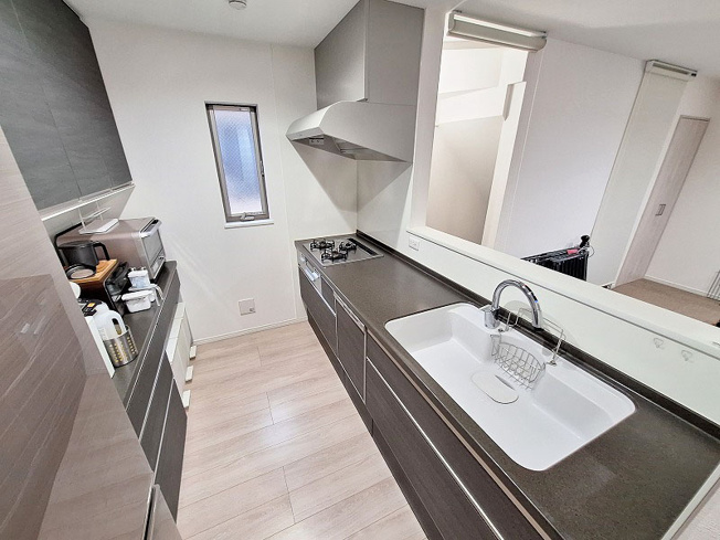 【キッチン】 | 朝霞市三原4丁目　中古一戸建住宅（成増店） | ガラストップコンロ・食洗器・タッチレス水栓付システムキッチン！
対面式につき家事の間もリビングにいるお子様に目を配れます。
※家具・照明等は含まれません。