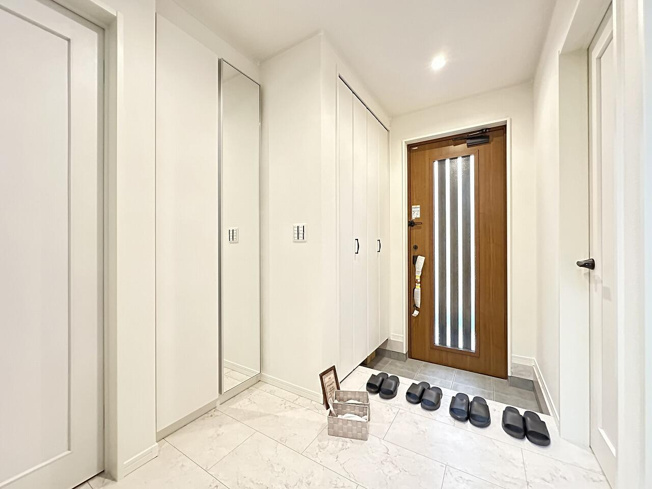 【玄関】 | トラストステージ×カラーズ　新座市野火止6丁目50期　全1棟 | 現地写真／大容量の全身鏡付きシューズボックス。
どこからでも開けやすく、家族で使いやすいユニバーサルデザインです。
※画像にはオプション商品も含まれております。