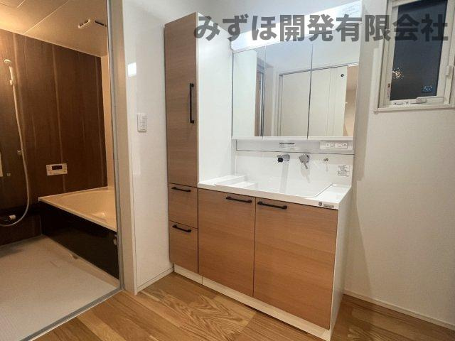 村山市楯岡二日町の独立洗面台|タオルや着替え、ストックなど十分な収納を備えた独立洗面台です。キッチン、LDKとそろえたパネルカラーもポイントです。