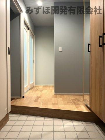 村山市楯岡二日町の玄関|斜め框で奥行きが広く見えるよう設計しました。グレーの壁紙と明るいフローリングがかわいらしい印象です。