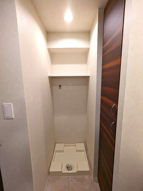 GRAND CONCIERGE浅草橋の設備|洗濯機置場はお手入れしやすい様に足高の防水パンで、排水溝を手前の中央に配置しています。