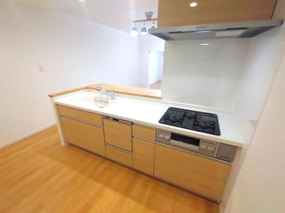 【キッチン】 | ファミール八事 | 清潔感のあるホワイトカウンターと木目調のキャビネットが、ナチュラルで落ち着いた印象を演出。三口コンロ＆グリル付きでお料理もスムーズ。