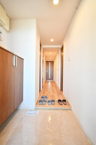 与野パークスクエアの玄関|白い壁にあった木目の建具。明るく広く見せる工夫が施されております♪センサーライトになっておりますので、電気の消し忘れもない＆帰宅時も明るい玄関でお出迎えしてくれる家族想いな玄関です(^^)