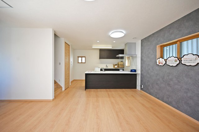 尼崎市東園田町2丁目新築一戸建て│2SLDK+駐車2台（車種制限有）の居間・リビング|リビング側からLDKを正面に撮影した内観写真です。入ってすぐのリビングの印象は、「広く落ち着いた空間」です。アクセントクロスを配置する事でLDKに一工夫加えています。