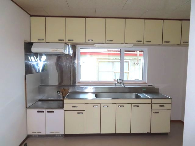 北見市留辺蘂町旭１区２３０番地５　中古売家のキッチン|システムキッチンは、吊戸棚やキャビネットなど、豊富な収納スペースあり、コンロやシンク台が天板で継ぎ目なく一体化しているため、掃除がしやすいです。