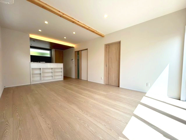 新築戸建　長野市三輪八丁目の居間・リビング|明るい白壁と天井、そして16帖のゆとりが相まって、実際の帖数以上に広く感じられる空間設計