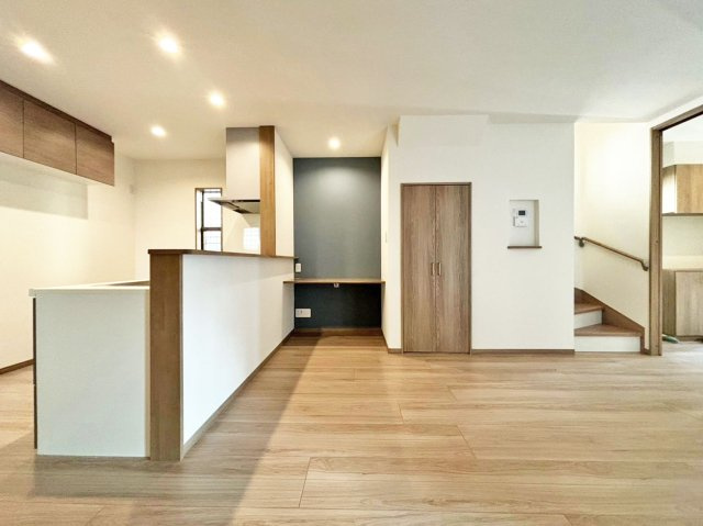 サニーサイド寺本1丁目新築戸建│3LDK+駐車駐輪可（車種制限有）の居間・リビング|1階LDKを洗面室入口から撮影した内観写真です。 入ってすぐのリビングの印象は、「広く落ち着いた空間」です。アクセントクロスを設けたスタディーコーナーを設けるなどLDKに一工夫加えています。