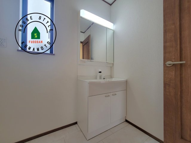 菊池市西寺第1-8棟（G号棟）の独立洗面台|毎日使うものだから清潔な空間を保ちたい水回り。洗面にはそんな願いを解消させてくれる収納アイデアが満載です。三面鏡の裏側にはキャビネットが現れ小物から背の高い物まで収納できます。