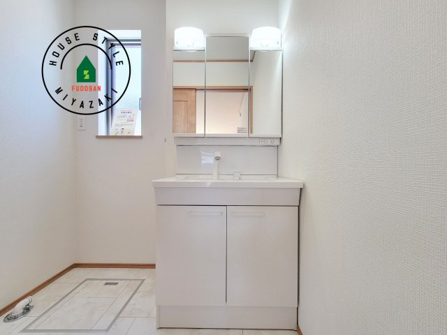 宮崎市太田1期-3棟（2号棟）の独立洗面台|毎日使うものだから清潔な空間を保ちたい水回り。洗面にはそんな願いを解消させてくれる収納アイデアが満載です。三面鏡の裏側にはキャビネットが現れ小物から背の高い物まで収納できます。