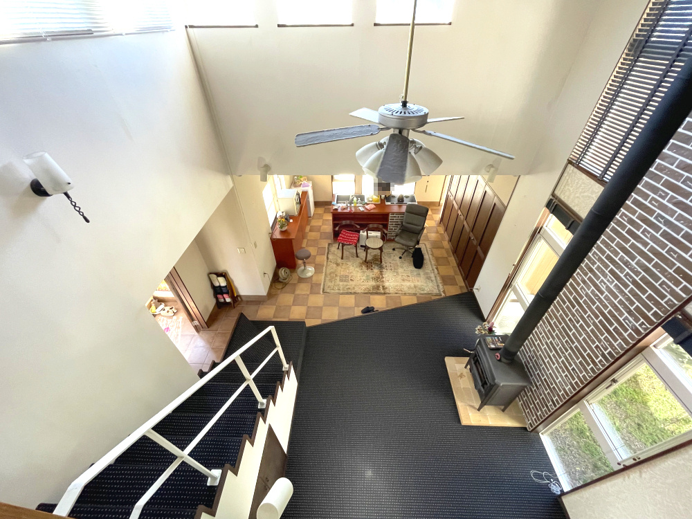 霧島市霧島田口字外戸口戸建てのキッチン|階段から見下ろしたホールとダイニングキッチンの様子です。とても開放感のある空間です。