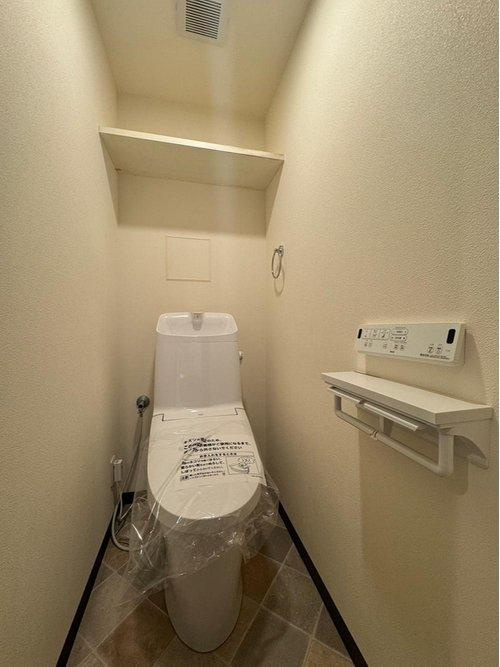 セザール一高南102のトイレ|シンプルで掃除がしやすいトイレ♪背面には吊戸棚を設置して収納力をアップ♪トイレットペーパーなどもスッキリ仕舞える◎