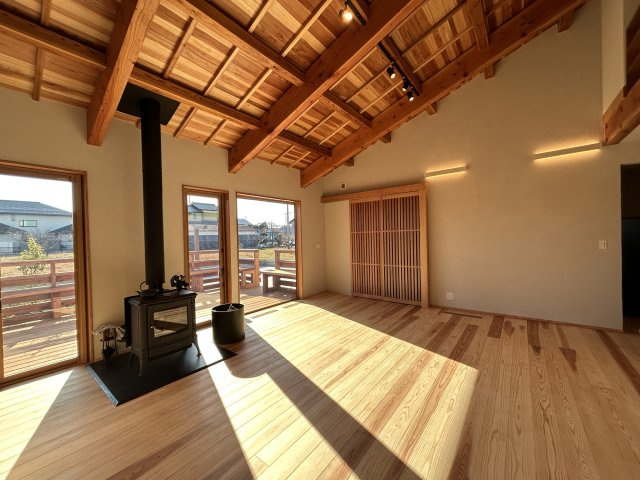 木田余東台1丁目　ガレージ付き住宅の居間・リビング|天井が高く開放的なリビング　あたたかな薪ストーブを設置