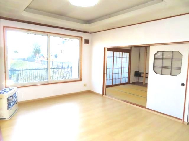 北見市清見町７１番地６６　中古売家　の居間・リビング|リビングの窓側（南側）と引戸を開放したイメージの和室の写真になります。