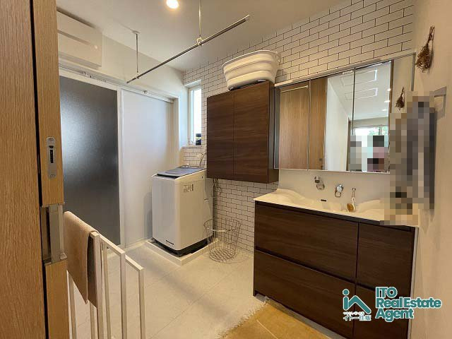 太秦一町芝町 中古戸建の独立洗面台|明るく生活感のある色調。機能性に富んだ三面鏡の洗面と採光窓が特徴です。