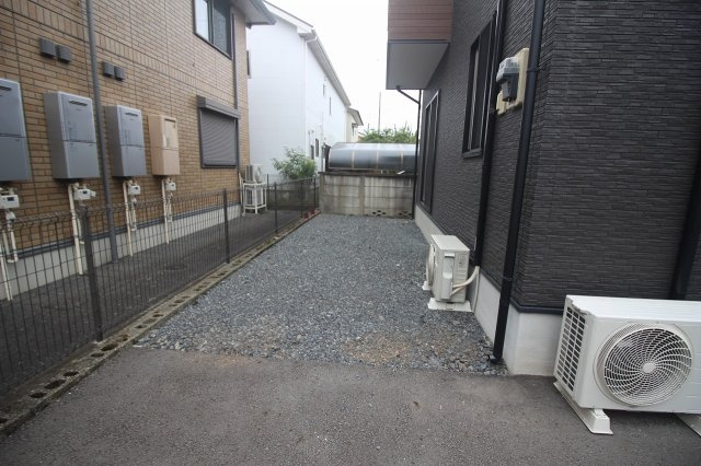 下野市駅東4丁目の庭|建物の横には、砕石敷きのすっきりとしたお庭スペース。雑草が生えにくく、お手入れがしやすいのが魅力です。自転車置き場や家庭菜園など、用途に合わせて活用できます。