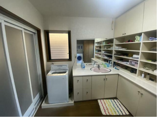 【洗面所】 | 甲府市宮前町 中古戸建 南東角地 キッチン2箇所付の7LDK | 4.5帖もある洗面所　収納棚が壁一面あり家族みんなの服が綺麗に収納出来ます。