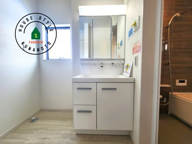 菊池郡大津町第2-1棟（1号棟）　の独立洗面台|毎日使うものだから清潔な空間を保ちたい水回り。洗面にはそんな願いを解消させてくれる収納アイデアが満載です。三面鏡の裏側にはキャビネットが現れ小物から背の高い物まで収納できます。