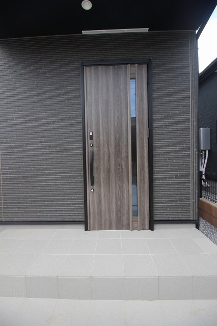 グラファーレ　小山市犬塚4丁目 2期　2号棟の玄関|木目調の玄関ドアがスタイリッシュな印象。落ち着きと高級感を兼ね備えたデザインでお客様を迎えます。