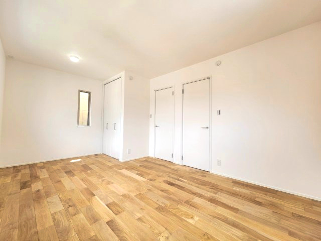 【価格改定】京都市西京区大原野上里鳥見町　の洋室|やさしい光を反射する白い壁と、温かみのある木目調のフローリングが調和した心地よい空間。