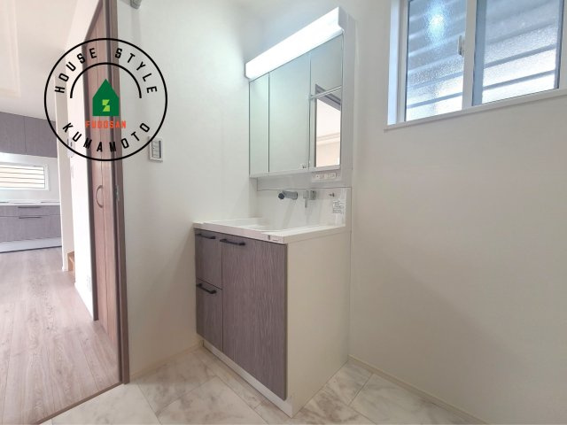 熊本市西区花園7丁目第7-6棟（1号棟）の独立洗面台|毎日使うものだから清潔な空間を保ちたい水回り。洗面にはそんな願いを解消させてくれる収納アイデアが満載です。三面鏡の裏側にはキャビネットが現れ小物から背の高い物まで収納できます。