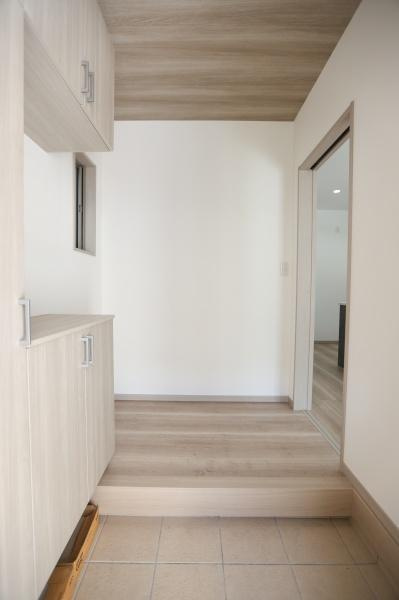 AG-HOUSE　上田町　B棟の玄関|玄関には明るい木目調の収納が設置されすっきりとした印象です。空間全体が明るく感じられます。段差部分も丁寧に仕上げられておりデザインに統一感があります。