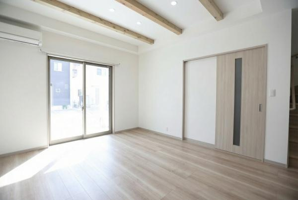 AG-HOUSE　上田町　B棟の居間・リビング|明るい光が差し込むリビングは開放感のある空間です。天井の木目調梁がアクセントになっています。広々としたフローリングがすっきりとした印象を与えます。