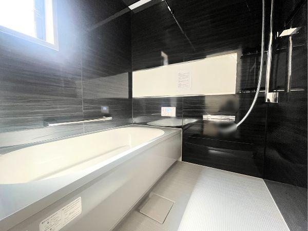 AG-HOUSE　光吉　A棟の浴室|ブラックの壁パネルが落ち着いた高級感を演出する浴室。ゆったり浸かれるバスタブに、浴室乾燥や追い焚き機能も搭載。窓付きで換気も良く、心身ともにリラックスできる癒しのバスタイムを叶えます♪