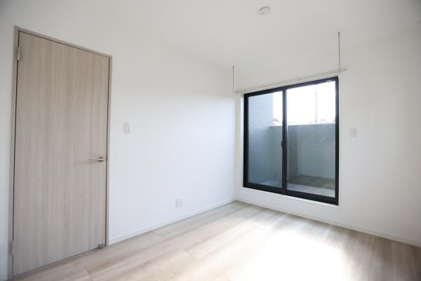 AG-HOUSE　光吉　A棟の洋室|大きな窓からたっぷりと光が差し込む明るい洋室。ナチュラルな木目調のフローリングと白壁が、清潔感と落ち着きを演出します。室内物干し付きで、天候に左右されず洗濯物が干せるのも嬉しいポイントです◎