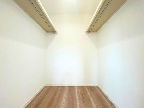 AG-HOUSE　光吉　A棟の収納|両側にハンガーパイプを備えたウォークインクローゼットは、衣類をたっぷり収納できるゆとりの空間。季節ごとの入れ替え不要で、毎日のコーディネートもスムーズ。スーツケースや小物類もまとめて整理できます！