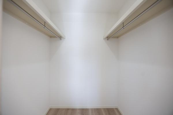 AG-HOUSE　光吉　A棟の収納|両側にハンガーパイプを備えたウォークインクローゼットは、衣類をたっぷり収納できるゆとりの空間。季節ごとの入れ替え不要で、毎日のコーディネートもスムーズ。スーツケースや小物類もまとめて整理できます！