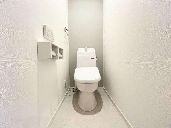 AG-HOUSE　光吉　A棟のトイレ|グレーのアクセントクロスが上品な印象を与える2階トイレ。コンパクトながらも清潔感があり、来客時にも気持ちよく使える空間です。壁付けリモコンや収納付きペーパーホルダーなど、使い勝手にもこだわっています♪