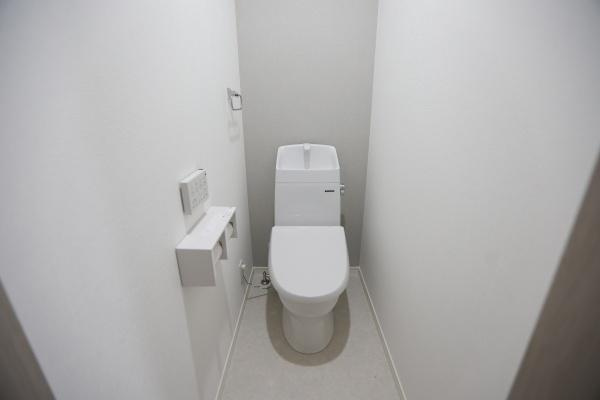 AG-HOUSE　光吉　A棟のトイレ|グレーのアクセントクロスが上品な印象を与える2階トイレ。コンパクトながらも清潔感があり、来客時にも気持ちよく使える空間です。壁付けリモコンや収納付きペーパーホルダーなど、使い勝手にもこだわっています♪